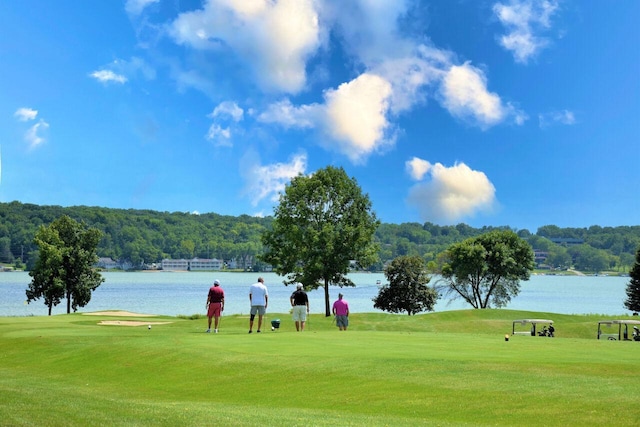 view of property's community with a water view and a lawn