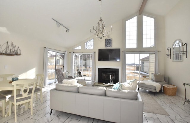 living room featuring an inviting chandelier, beam ceiling, high vaulted ceiling, and rail lighting