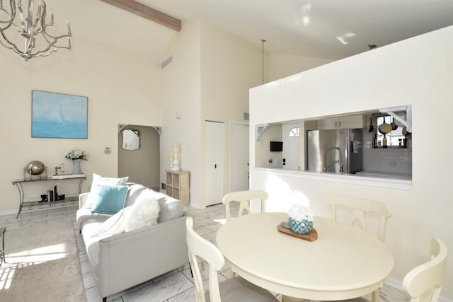 dining room with high vaulted ceiling and beamed ceiling