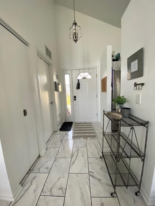 entrance foyer featuring high vaulted ceiling