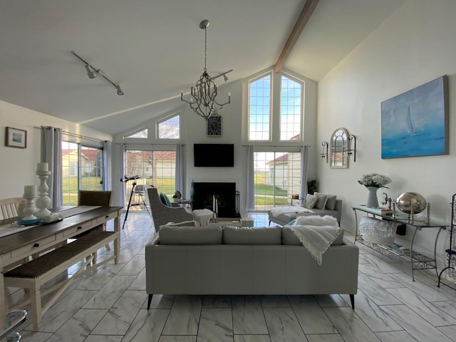 living room featuring beamed ceiling, high vaulted ceiling, track lighting, and an inviting chandelier