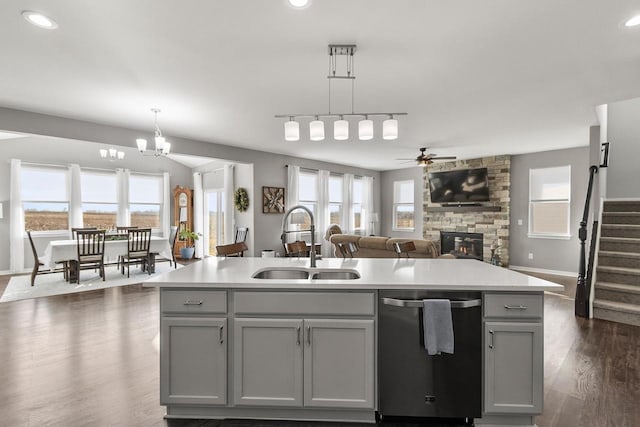 kitchen with gray cabinetry, pendant lighting, and a kitchen island with sink