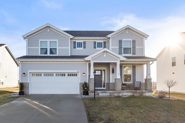 craftsman-style house featuring covered porch, a front yard, and a garage