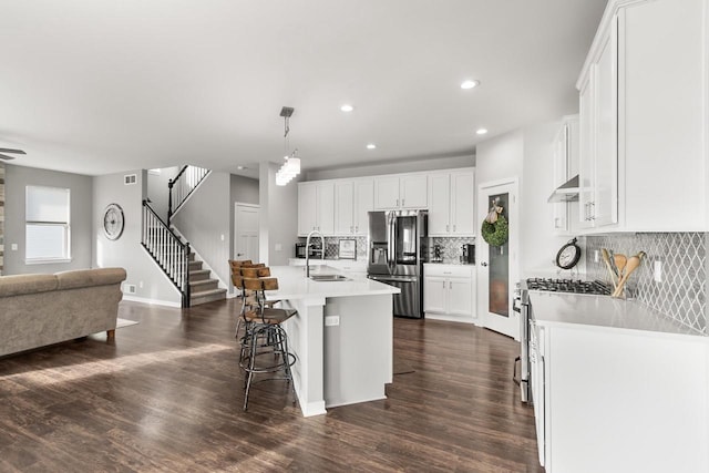 kitchen with white cabinetry, sink, pendant lighting, a center island with sink, and appliances with stainless steel finishes