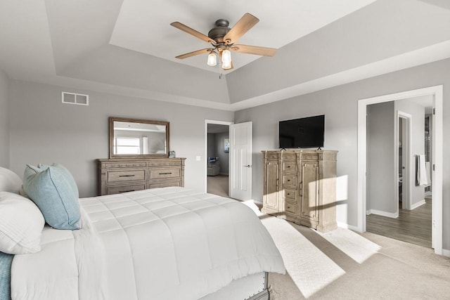 bedroom featuring a tray ceiling, ceiling fan, and light colored carpet