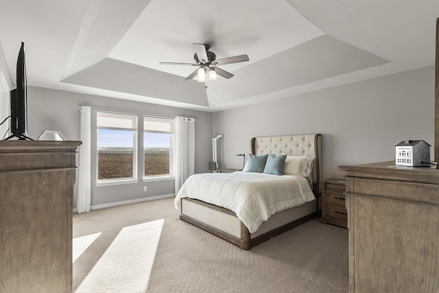 bedroom with a tray ceiling, ceiling fan, and light colored carpet