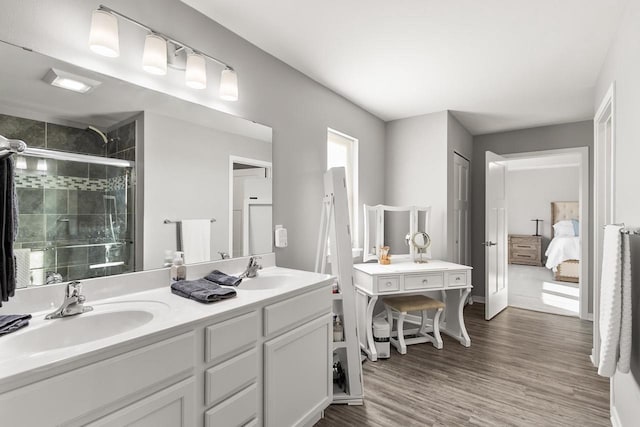 bathroom with hardwood / wood-style floors, vanity, and an enclosed shower