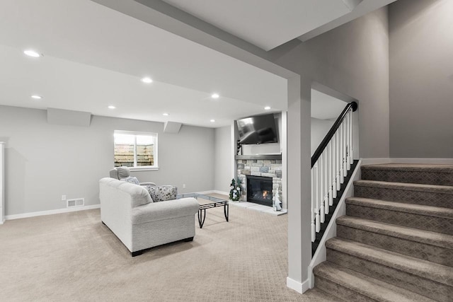 living room with light colored carpet and a stone fireplace