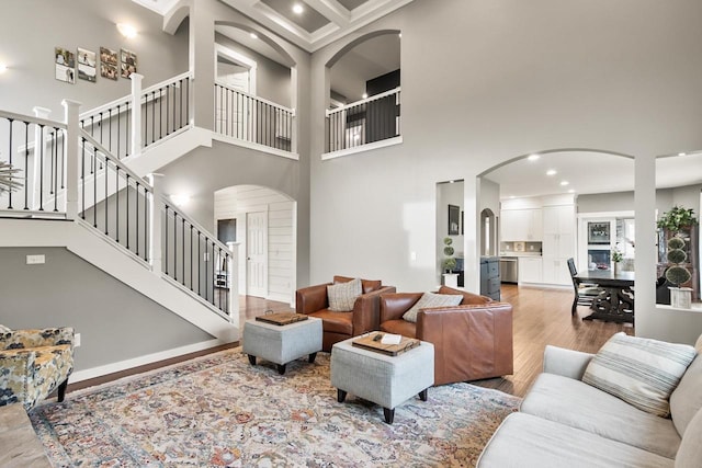 living room with crown molding, a high ceiling, and hardwood / wood-style flooring