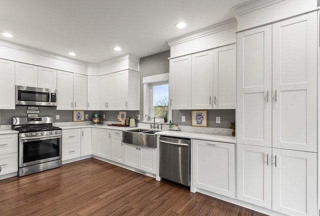 kitchen with white cabinets, appliances with stainless steel finishes, dark wood-type flooring, and sink