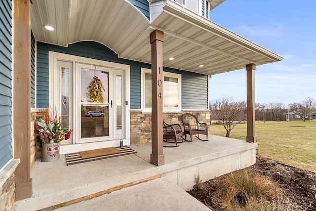 entrance to property with a lawn and covered porch