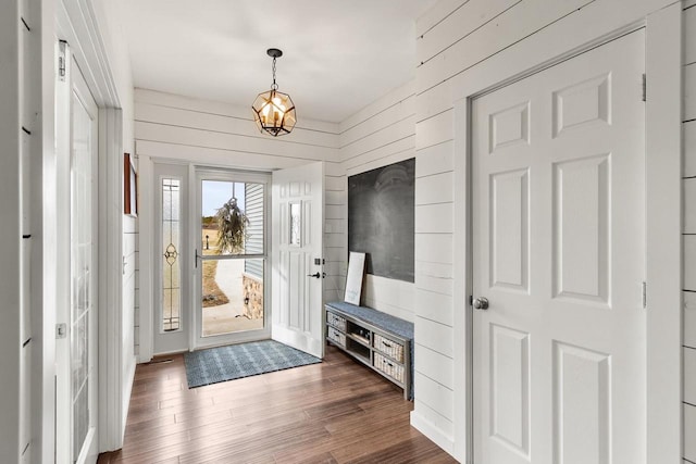 entrance foyer with wooden walls and dark wood-type flooring