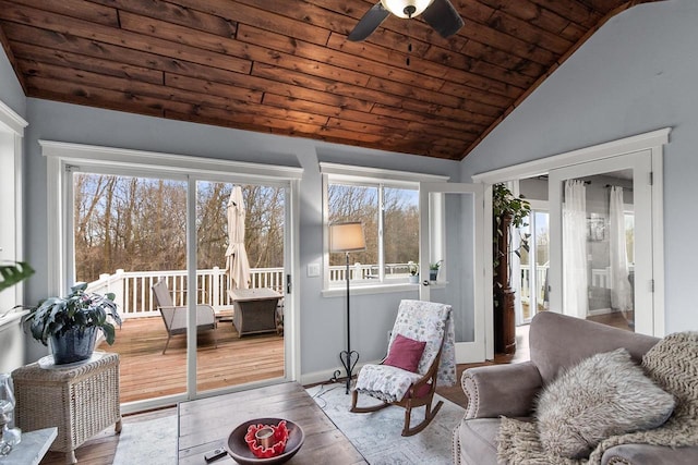 sunroom featuring a healthy amount of sunlight, ceiling fan, wood ceiling, and lofted ceiling