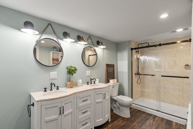 bathroom with vanity, wood-type flooring, a shower with shower door, and toilet