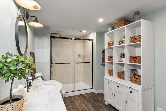 bathroom with vanity, hardwood / wood-style flooring, toilet, and a shower with shower door