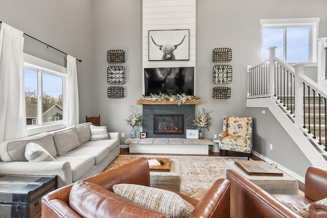 living room with hardwood / wood-style floors and a tiled fireplace