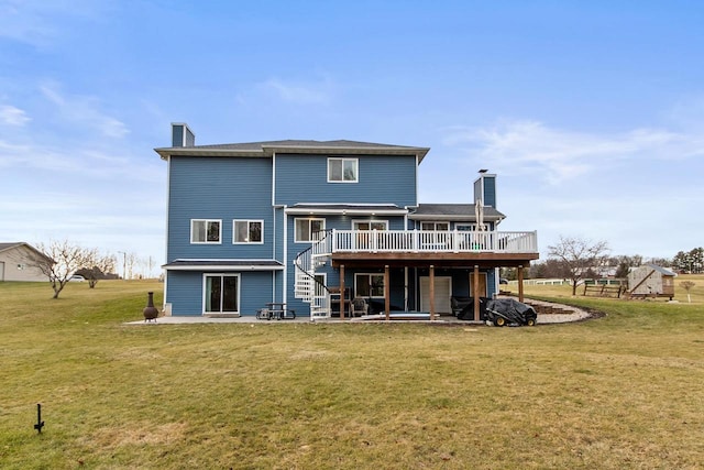 rear view of house with a patio, a lawn, and a wooden deck