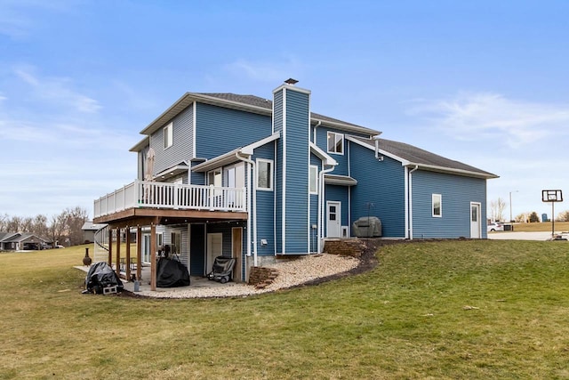 back of house featuring a lawn and a deck