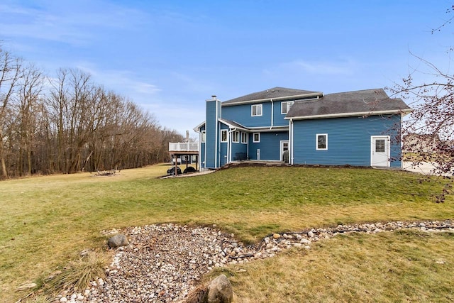 back of house featuring a lawn and a wooden deck