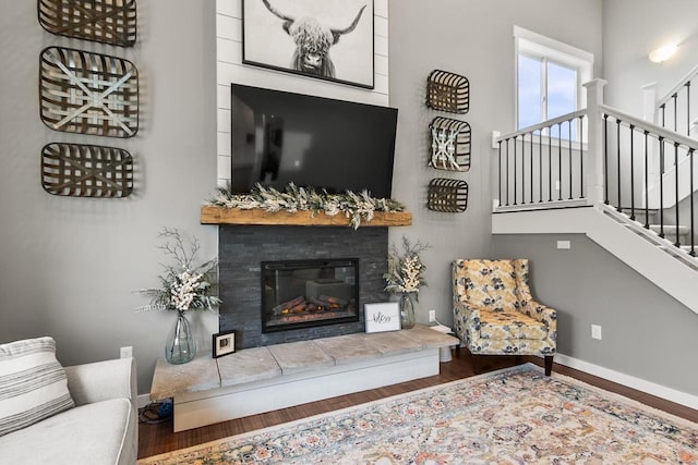 living room with hardwood / wood-style flooring and a tiled fireplace