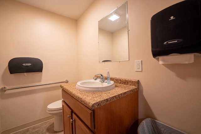 bathroom featuring tile patterned floors, vanity, and toilet