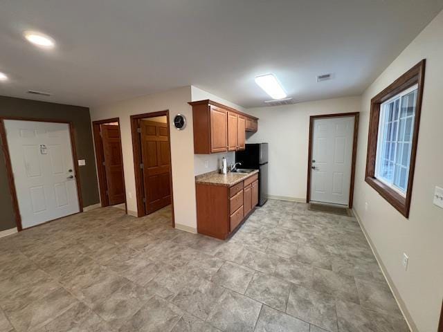 kitchen featuring black refrigerator and sink