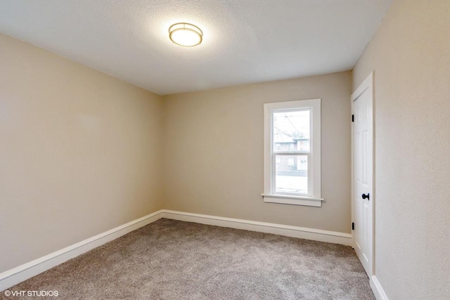 empty room with carpet and a textured ceiling