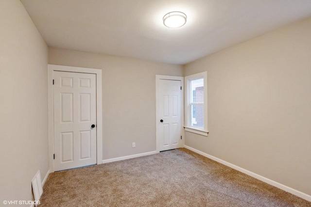 unfurnished bedroom featuring light colored carpet and a closet