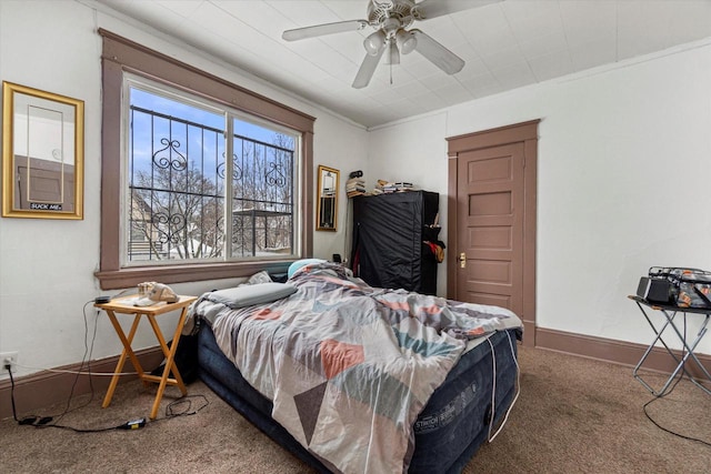 carpeted bedroom featuring ceiling fan and crown molding