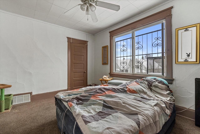 bedroom with dark colored carpet, ceiling fan, and crown molding