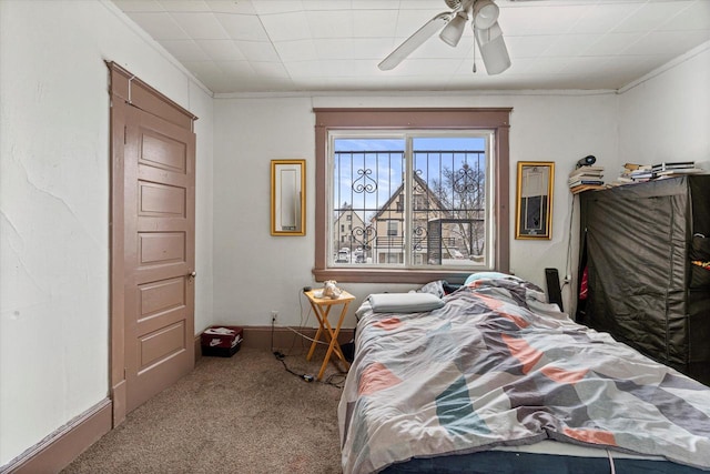 bedroom with ceiling fan, crown molding, and carpet