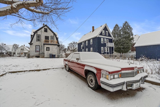 view of snow covered back of property