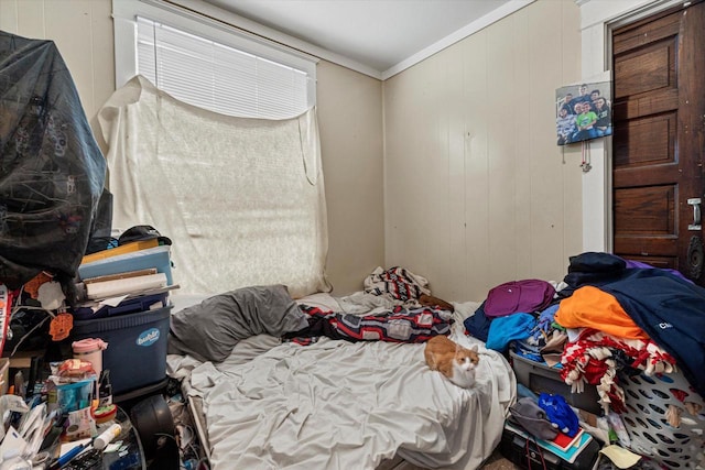 bedroom featuring wooden walls and ornamental molding