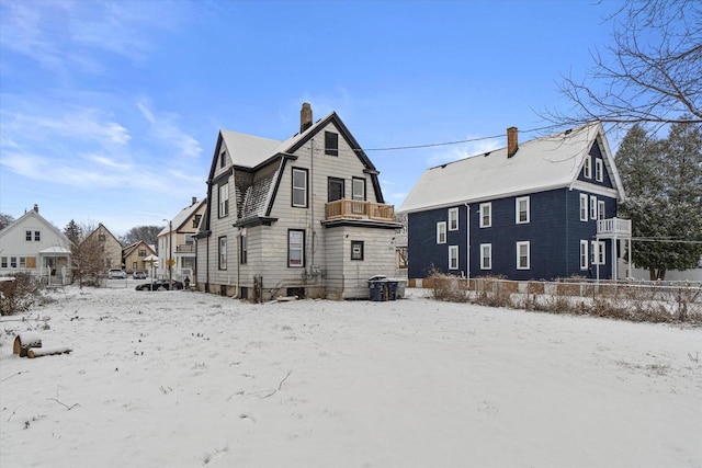 view of snow covered back of property