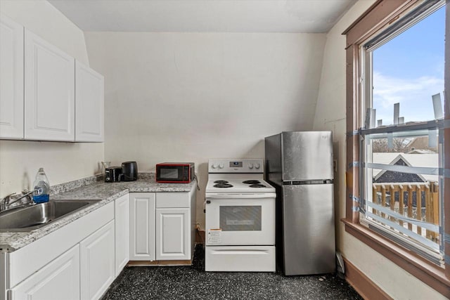 kitchen featuring stainless steel refrigerator, white cabinetry, sink, white electric range, and light stone counters