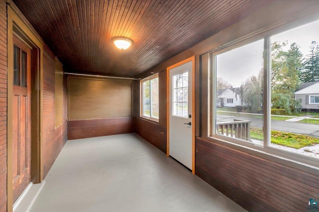 unfurnished sunroom with wooden ceiling