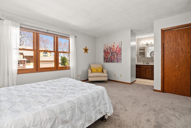 2022 27th St, Monroe, WI 53566 - bedroom featuring light colored carpet, baseboards, ensuite bathroom, and a sink