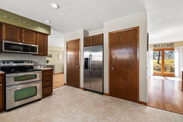 2022 27th St, Monroe, WI 53566 - kitchen with stainless steel appliances, baseboards, and light countertops
