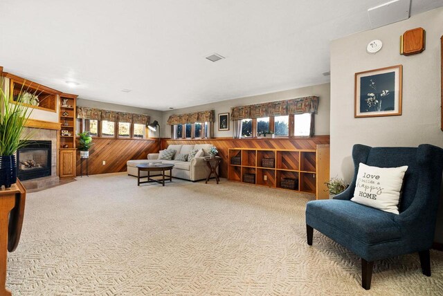 2022 27th St, Monroe, WI 53566 - living room featuring visible vents, a wainscoted wall, a tiled fireplace, carpet floors, and wood walls