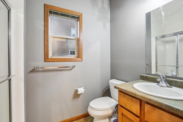 bathroom featuring vanity, toilet, and a shower with door