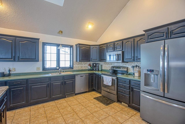 kitchen featuring sink, hanging light fixtures, stainless steel appliances, tasteful backsplash, and vaulted ceiling