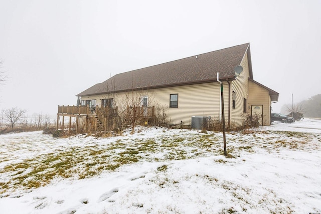 view of snowy exterior featuring central air condition unit