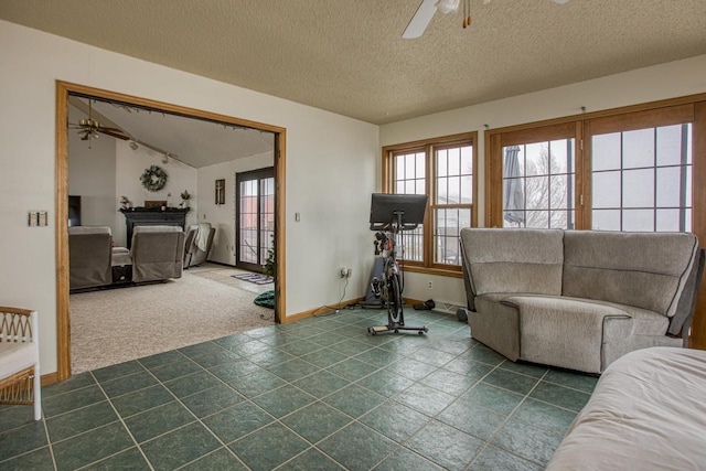 carpeted living room featuring a textured ceiling and ceiling fan