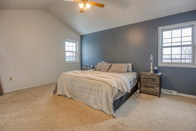 bedroom featuring a textured ceiling, ceiling fan, light colored carpet, and vaulted ceiling