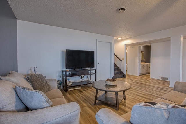 living room featuring wood-type flooring and a textured ceiling