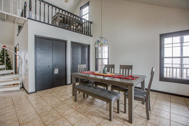 dining space featuring tile patterned flooring and a high ceiling