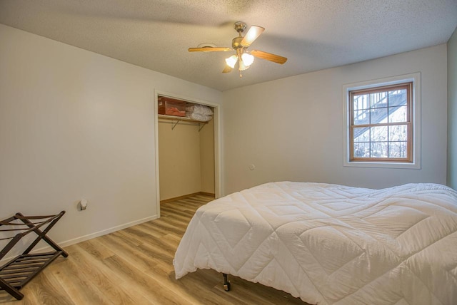 bedroom with ceiling fan, a closet, a textured ceiling, and light hardwood / wood-style flooring