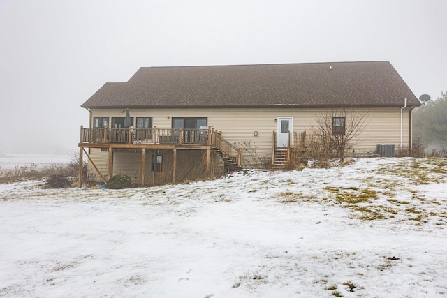 snow covered house with central AC unit