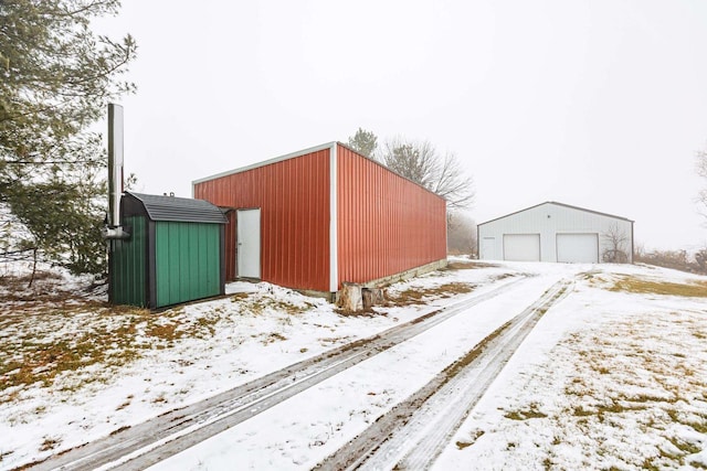 snow covered structure featuring a garage