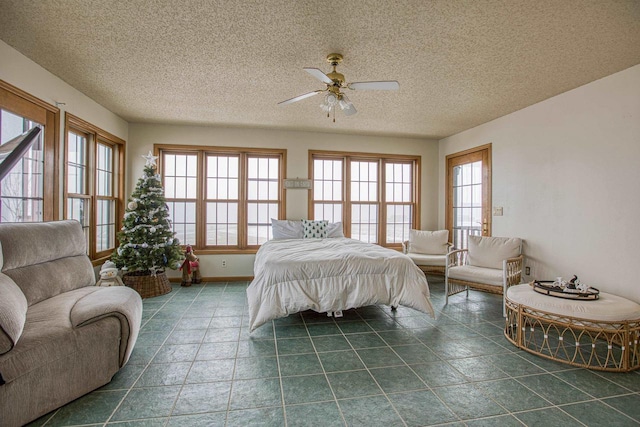 bedroom with ceiling fan, a textured ceiling, and multiple windows